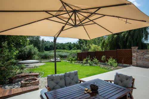 a patio with a table and an umbrella at Vendégház az Evezőhöz in Szigetszentmiklós