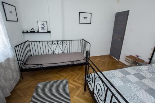 1 dormitorio con 1 cama y suelo de madera en Vendégház az Evezőhöz, en Szigetszentmiklós