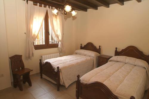a bedroom with two beds and a window at Apartamentos Los Hebiles in Jerte