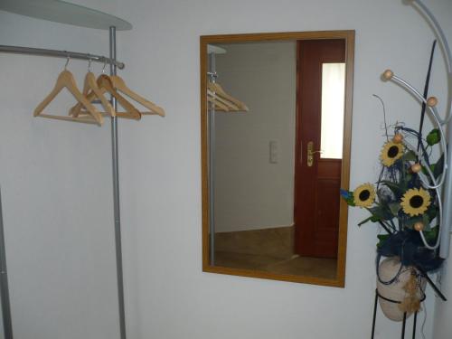 a mirror on a wall with a vase of sunflowers at Appartement Gasser in Anras