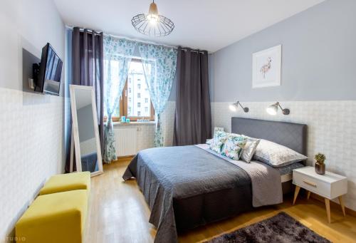 ワルシャワにあるClickTheFlat Sienna Center Apart Roomsのベッドルーム1室(ベッド1台、黄色い椅子付)
