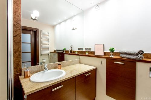 W łazience znajduje się umywalka i lustro. w obiekcie ClickTheFlat Sienna Center Apart Rooms w Warszawie