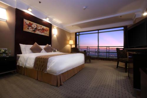 a hotel room with a large bed and a large window at Qingdao Blue Horizon Hotel - Laoshan in Qingdao