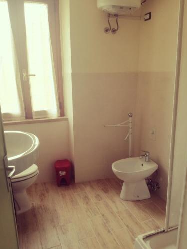 a bathroom with a white toilet and a sink at B&B La Rondinella in Montecerboli
