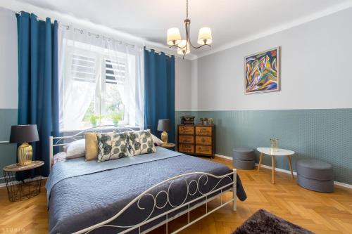 ClickTheFlat Apartment Chmielna 7 في وارسو: غرفة نوم بسرير والجدران الزرقاء ونافذة
