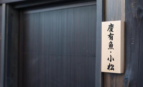 a sign on a door with writing on it at 慶有魚·小松(Kyotofish·Komatsu) in Kyoto