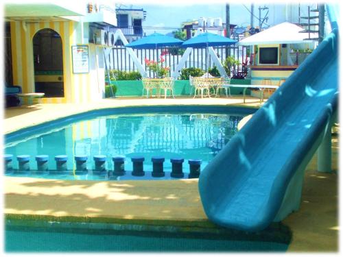 a slide in a swimming pool with a swimming pool at Suites Angelopolis in Acapulco