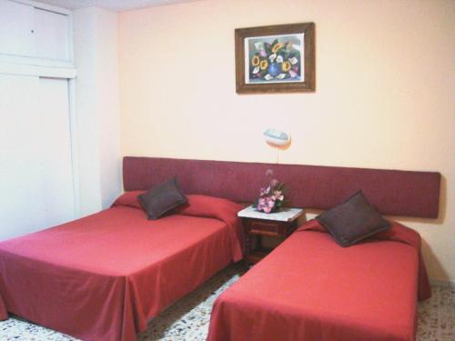 a hotel room with two beds and a table at Suites Angelopolis in Acapulco