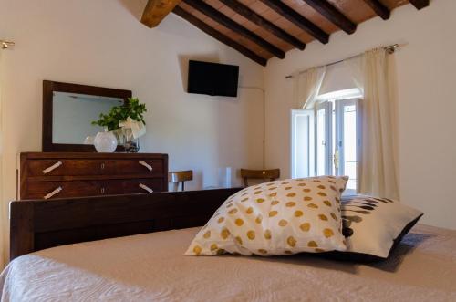 a bedroom with a bed with a dresser and a television at Ai Bastiani in Capannori