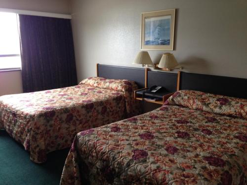 a hotel room with two beds and a window at Moby Dick Inn in Prince Rupert