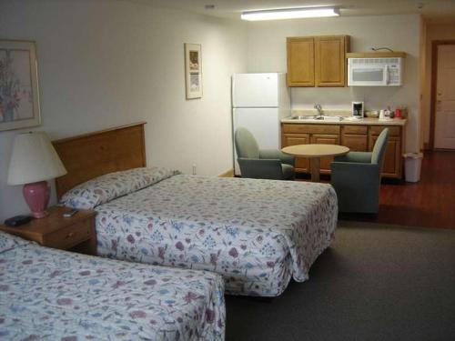 a hotel room with two beds and a kitchen at Stevens Pass Motel in Gold Bar