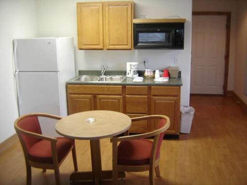 a kitchen with a table and chairs and a white refrigerator at Stevens Pass Motel in Gold Bar