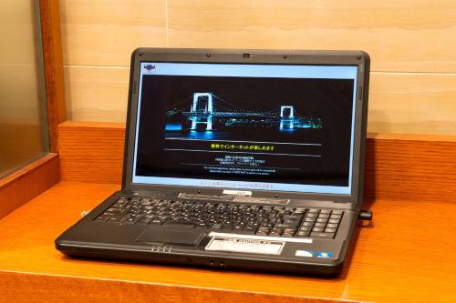 a laptop computer sitting on top of a wooden table at Hotel Villa Fontaine Tokyo-hatchobori in Tokyo