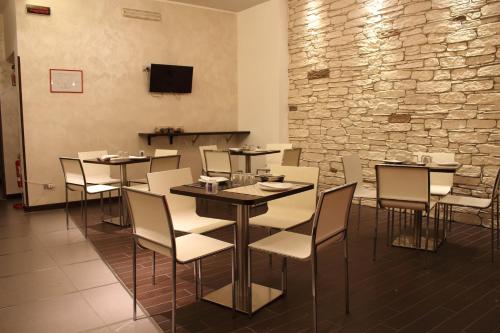 a dining room with tables and chairs and a stone wall at Albergo Miramonti in Potenza