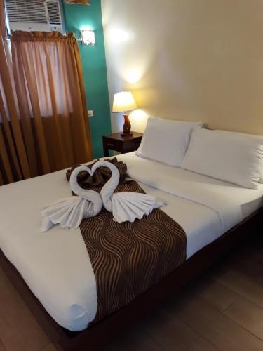 a bedroom with a bed with towels on it at Sea Garden Resort Iloilo in Iloilo City