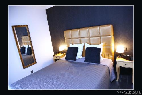 a bedroom with a large bed with blue sheets and a mirror at V E R O N E - Rooms & Suites - Liège - Rocourt in Liège