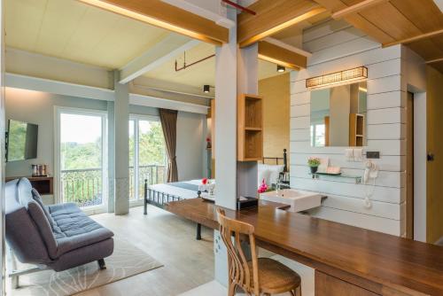 a kitchen and living room with a desk and a chair at Dang Derm In The Park Khaosan in Bangkok