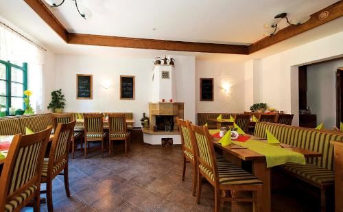 a restaurant with wooden tables and chairs and a fireplace at Kurparkstübl Bad Schandau in Bad Schandau