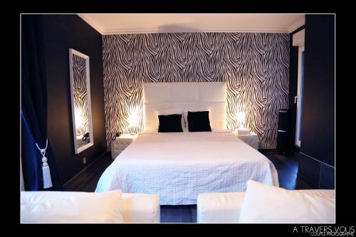 a bedroom with a large white bed with two pillows at V E R O N E - Rooms & Suites - Liège - Rocourt in Liège