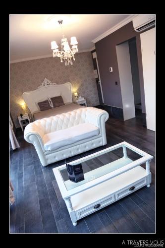 a living room with a white bed and a coffee table at V E R O N E - Rooms & Suites - Liège - Rocourt in Liège