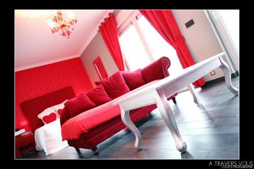 a living room with a red couch and a table at V E R O N E - Rooms & Suites - Liège - Rocourt in Liège
