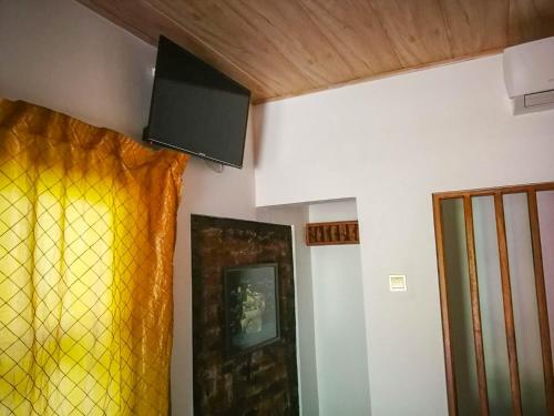a room with a yellow curtain and a door at Green Cottage in Anuradhapura