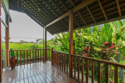 a porch with a wooden deck with plants at Villa D'Carik Bali in Denpasar