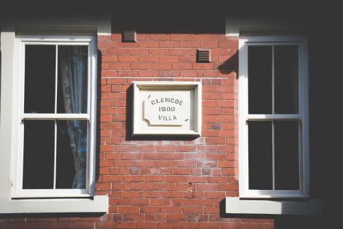 a brick wall with two windows and a sign on it at Glencoe Villa Guesthouse in Featherstone