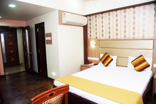 a hotel room with a bed and a chair at Hotel Indiana Inn in Navi Mumbai