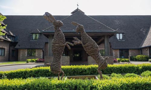 a statue of two bears in front of a house at Kettering Park Hotel and Spa in Kettering