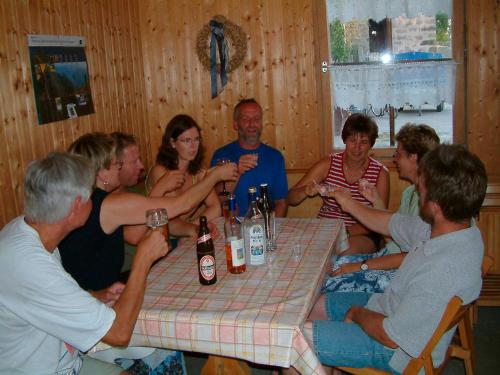 a group of people sitting around a table with bottles of wine at Ferienhof Winkler in Merkendorf