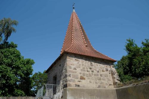 a building with a tower on top of a wall at Ferienhof Winkler in Merkendorf