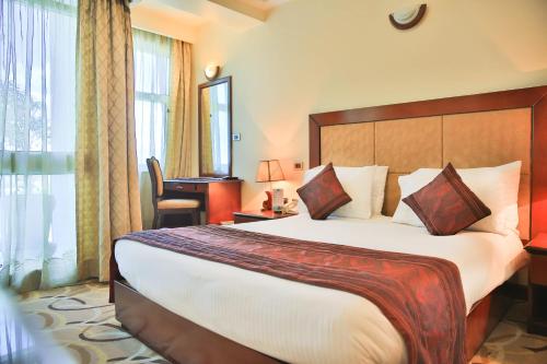 a hotel room with a large bed and a window at Swiss Inn Nexus Hotel in Addis Ababa