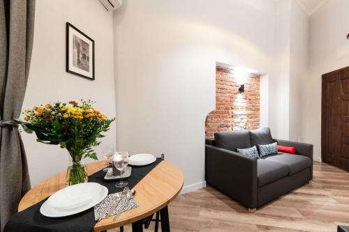 a living room with a table and a couch at DIETLA 99 APARTMENTS - IDEAL LOCATION - in the heart of Krakow in Kraków