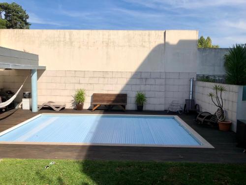 ein Pool mit einer Bank neben einer Wand in der Unterkunft Annex bedroom-Oporto Garden in Porto