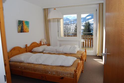 two beds in a bedroom with a window at Apartment in Disentis in Disentis