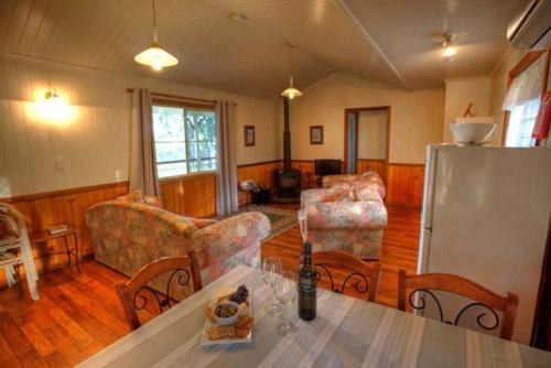 sala de estar con mesa y nevera en Accommodation Creek Cottages & Sundown View Suites en Ballandean