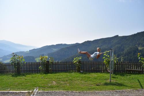 a man is jumping over a fence at Ferienhaus Schleinzer in Prebl