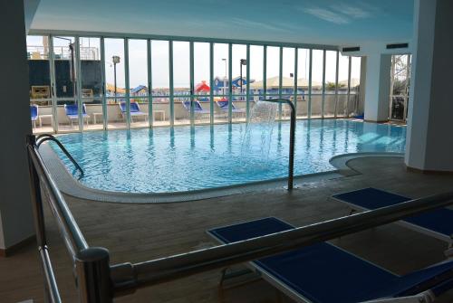 una grande piscina con scivolo in un edificio di Hotel Negresco a Cattolica