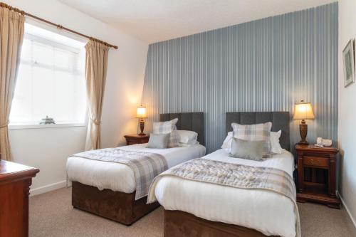 a hotel room with two beds and a window at Bron Eifion Hotel in Criccieth