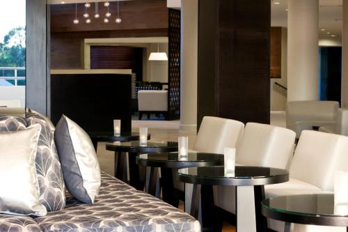 a dining room with tables and white chairs at Sofitel Noosa Pacific Resort in Noosa Heads