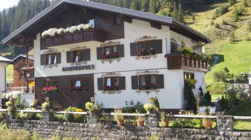 a building with flowers in front of it at Pension Hartenfels in Lech am Arlberg