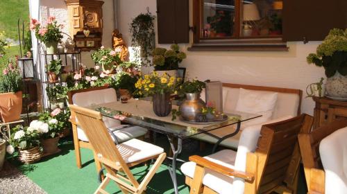 a room with a table and chairs and flowers at Pension Hartenfels in Lech am Arlberg