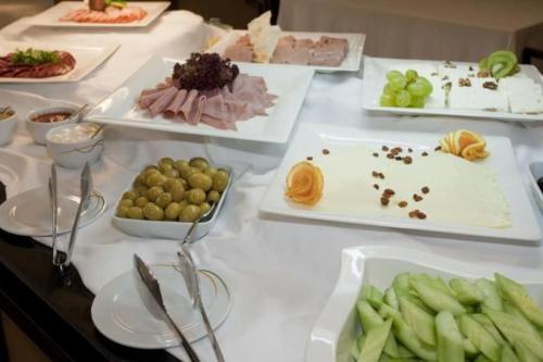 een tafel met verschillende soorten levensmiddelen op borden bij GT Aspen House Apartments in Bansko