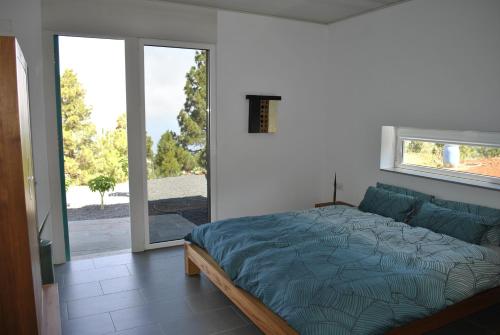 1 dormitorio con 1 cama y puerta corredera de cristal en VILLA HORIZONTE, en Puntagorda
