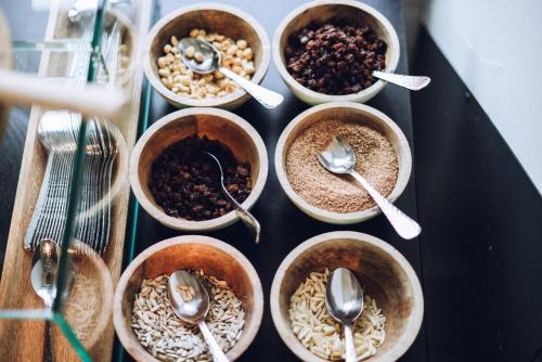 a group of bowls of food with spoons on a table at Thehotel at LIPPISCHER HOF in Bad Salzuflen