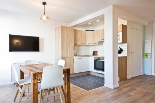 une cuisine et une salle à manger avec une table et des chaises en bois dans l'établissement Pick A Flat - Bastille / Charonne apartments, à Paris