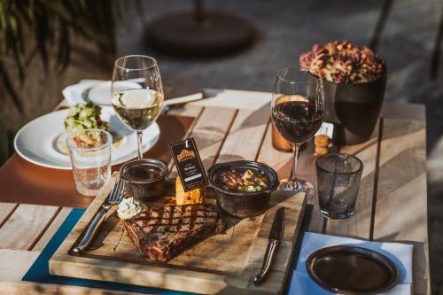 a table with a plate of food and glasses of wine at Thehotel at LIPPISCHER HOF in Bad Salzuflen