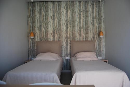 two beds sitting next to each other in a room at Sunrise Studios Resort in Skala Potamias