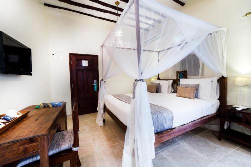 a bedroom with a bed with a mosquito net at Maru Maru Hotel in Zanzibar City